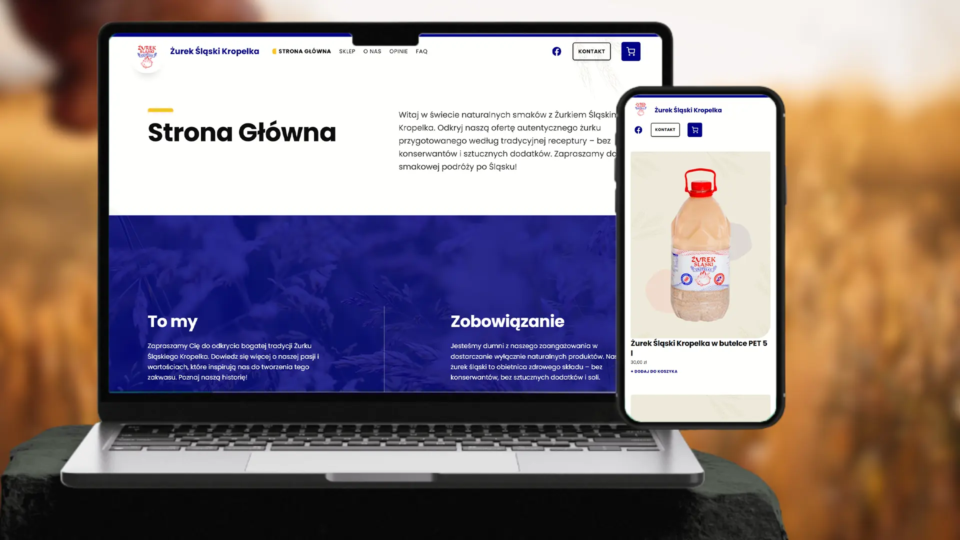 Laptop i telefon w otoczeniu pszenicy na których prezentuje się strona internetowa Żurek Śląski Kropelka